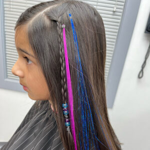 Haircut and style along with a hair braid, colored fake hair, and shimmery blue hair tinsel